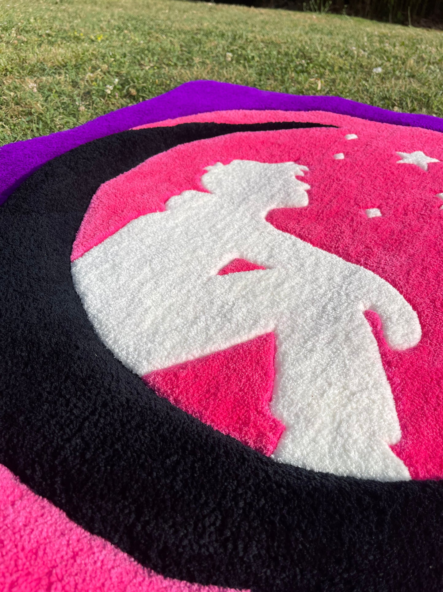 Détail du travail de carving (sculpture aux ciseaux) sur la silhouette blanche et la lune texturée du tapis mural.