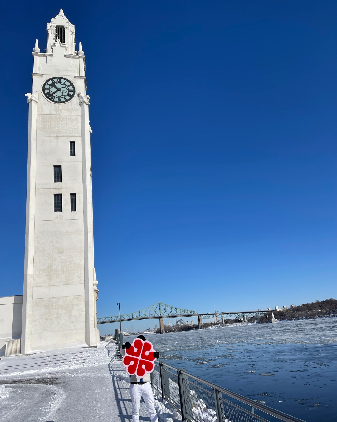 Création originale Signé Léon : un tapis tufté à la main représentant le logo rouge de la ville de Montréal, mis en scène en plein hiver devant la Tour de l'Horloge (le phare de Montréal) et les rives glacées du fleuve.