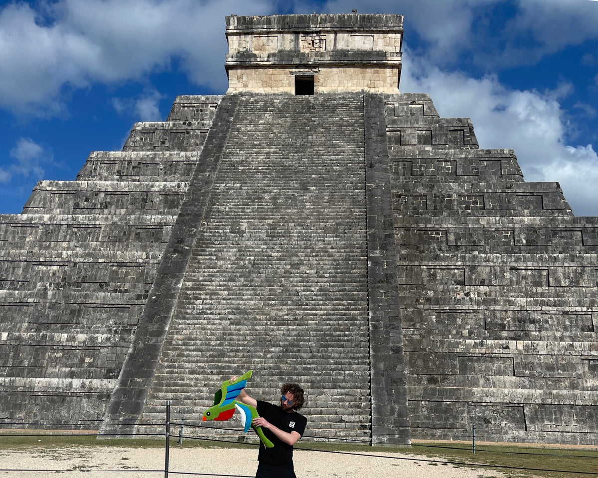 L'artisan de Signé Léon présente sa création originale tuftée à la main, un tapis en forme d'oiseau Quetzal, mis en scène au pied de la célèbre pyramide maya de Chichén Itzá au Mexique.