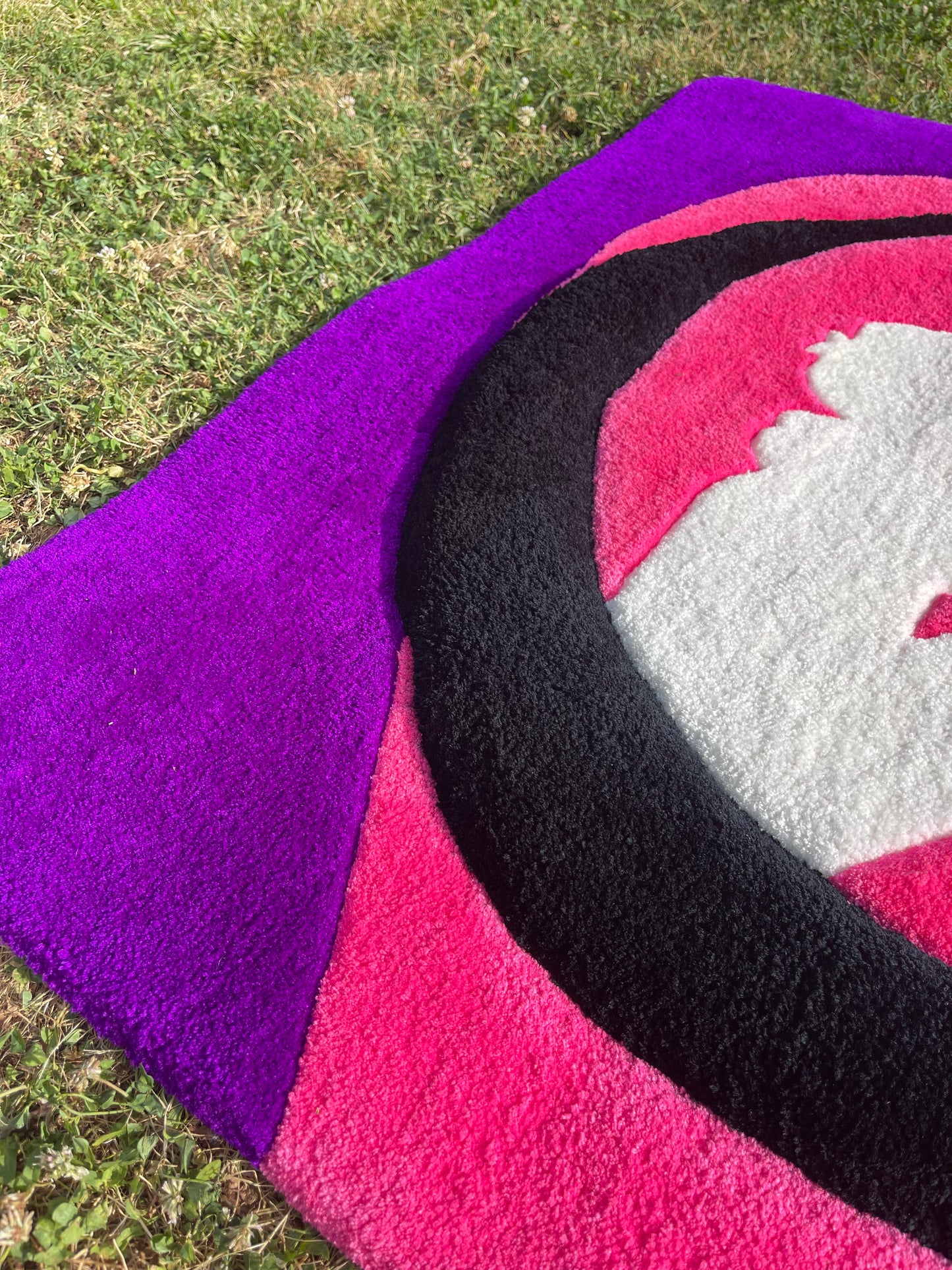 Texture de la laine acrylique premium et contraste entre la lune noire en relief et le fond violet profond du tapis.